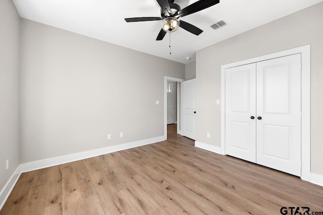 unfurnished bedroom with ceiling fan, light hardwood / wood-style flooring, and a closet