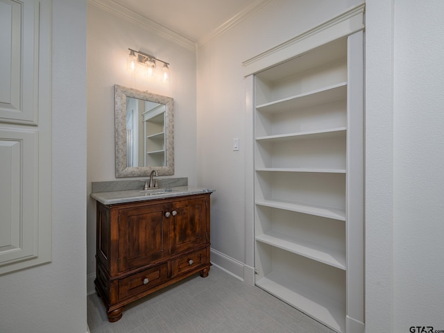 bathroom featuring crown molding, vanity, and built in shelves