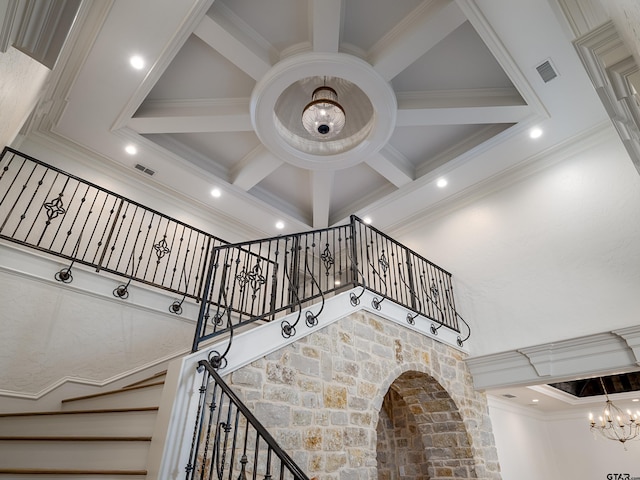 staircase featuring ornamental molding, coffered ceiling, a chandelier, and beam ceiling