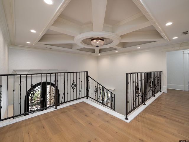 corridor featuring crown molding, wood-type flooring, coffered ceiling, and beam ceiling