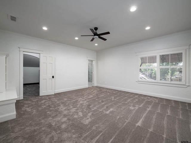 spare room with crown molding, ceiling fan, and dark colored carpet