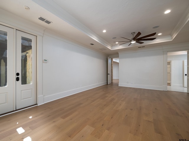 unfurnished room featuring crown molding, a raised ceiling, ceiling fan, and light wood-type flooring