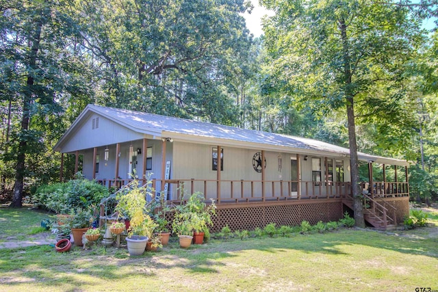 view of front of property featuring a front lawn and a wooden deck