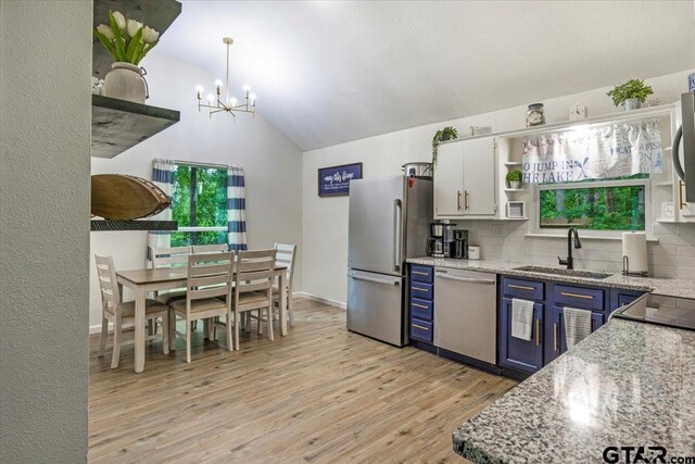 194 Debra Dr, Bullard, TX 75757 - kitchen with open shelves, stainless steel appliances, a sink, blue cabinetry, and tasteful backsplash