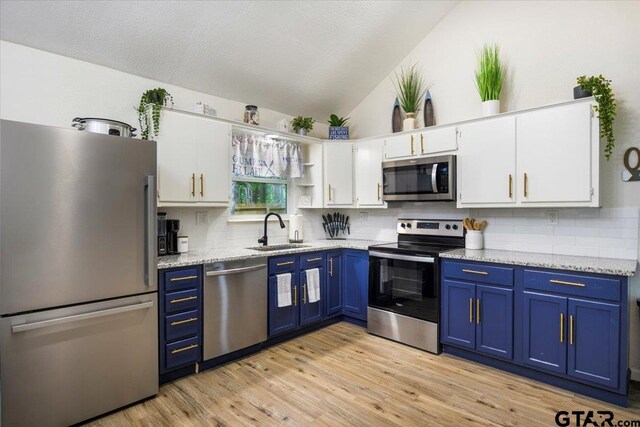 194 Debra Dr, Bullard, TX 75757 - kitchen featuring appliances with stainless steel finishes, a sink, blue cabinets, white cabinetry, and vaulted ceiling