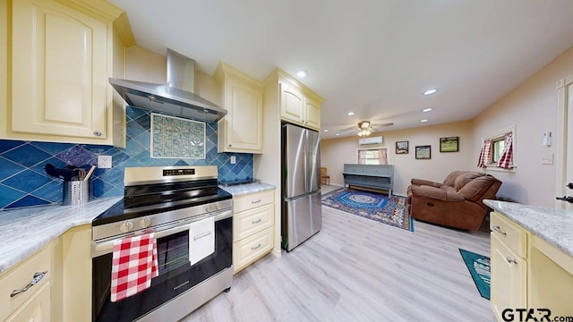 kitchen featuring cream cabinetry, wall chimney exhaust hood, and appliances with stainless steel finishes