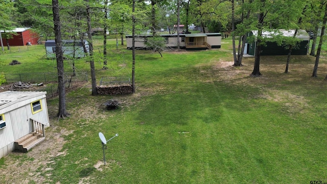 view of yard featuring an outdoor structure and fence