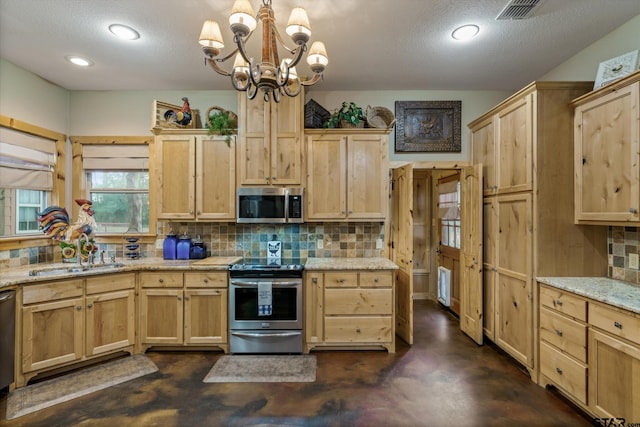 kitchen featuring decorative backsplash, sink, a chandelier, and appliances with stainless steel finishes