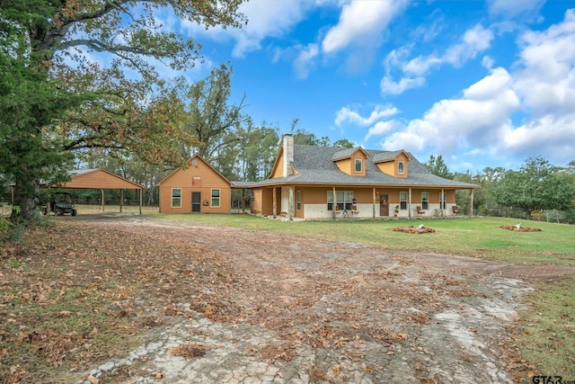 rear view of property with a porch, a carport, and a lawn