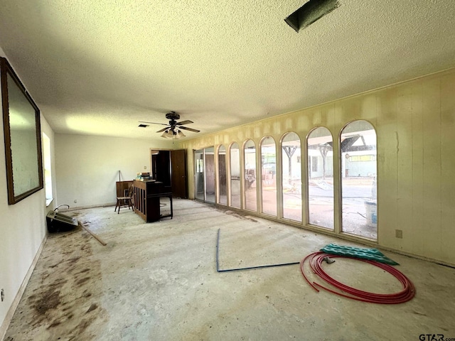 unfurnished sunroom featuring ceiling fan