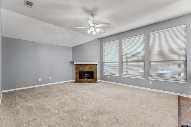 unfurnished living room with lofted ceiling, a wealth of natural light, and light carpet