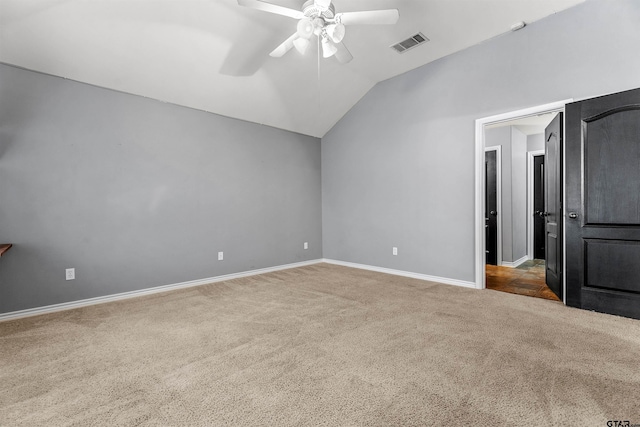 unfurnished bedroom with ceiling fan, lofted ceiling, and dark carpet