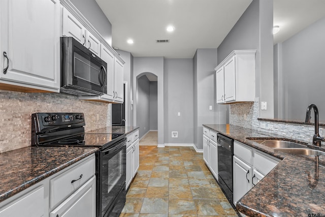 kitchen featuring white cabinets, decorative backsplash, black appliances, sink, and dark stone countertops