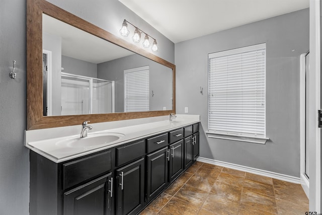 bathroom featuring a shower with door and vanity