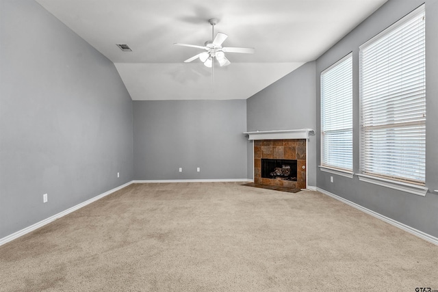 unfurnished living room with plenty of natural light, lofted ceiling, and light colored carpet