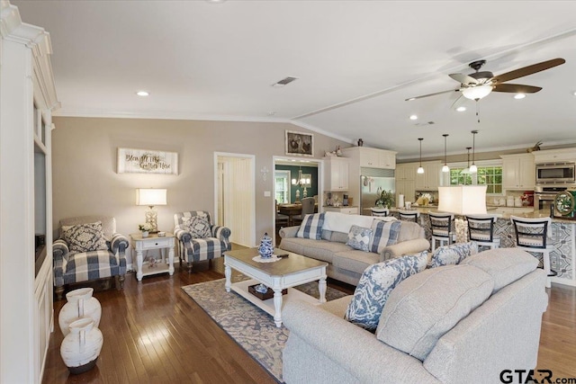 living room featuring dark hardwood / wood-style flooring, ceiling fan, crown molding, and vaulted ceiling