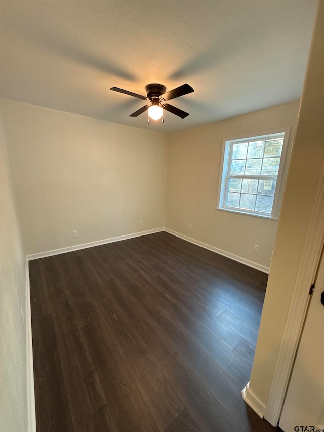 spare room with dark wood-type flooring and ceiling fan