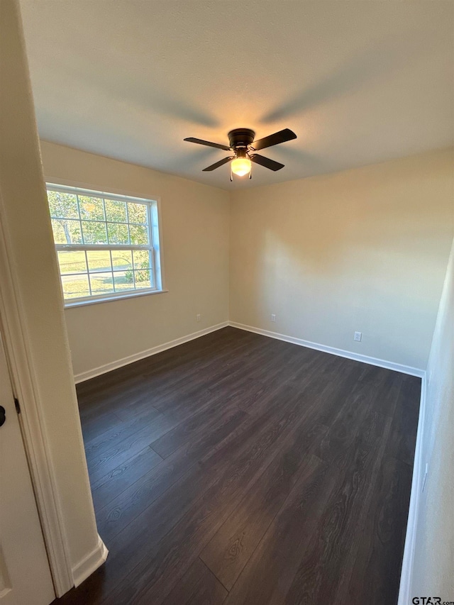 spare room with dark hardwood / wood-style floors and ceiling fan