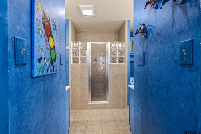 bathroom featuring tile patterned floors and a tile shower