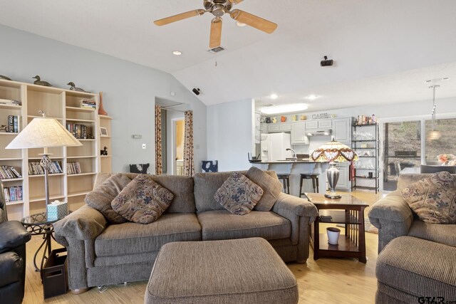 living room with visible vents, light wood-style flooring, a ceiling fan, and vaulted ceiling