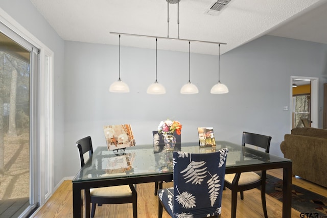 dining space featuring visible vents and light wood-style floors