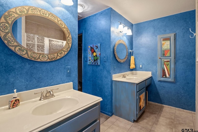 full bath featuring a sink, two vanities, and tile patterned floors