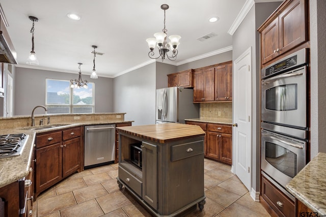 213 Coventry St, Bullard, TX 75757 - kitchen featuring a chandelier, stainless steel appliances, ornamental molding, tasteful backsplash, and decorative light fixtures