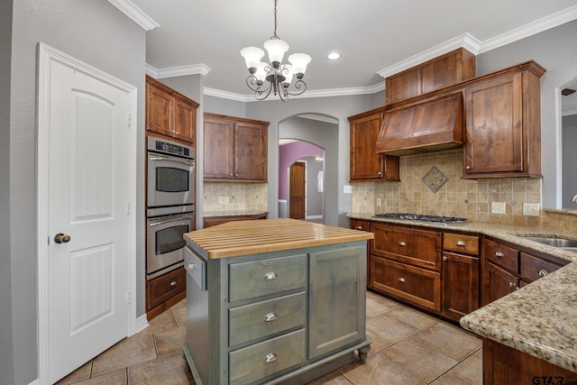 213 Coventry St, Bullard, TX 75757 - kitchen with stainless steel appliances, arched walkways, a chandelier, premium range hood, and decorative backsplash