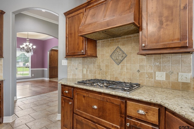 213 Coventry St, Bullard, TX 75757 - kitchen featuring stainless steel gas stovetop, premium range hood, ornamental molding, arched walkways, and brown cabinets