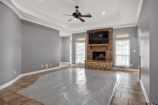 213 Coventry St, Bullard, TX 75757 - unfurnished living room with ceiling fan, crown molding, a tray ceiling, stone tile floors, and a brick fireplace