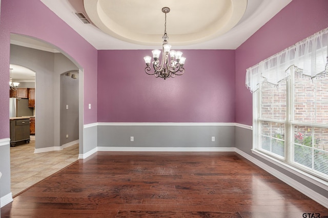 213 Coventry St, Bullard, TX 75757 - spare room with a chandelier, light wood-type flooring, arched walkways, and a raised ceiling