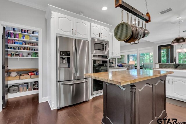 13452 Karah Ln, Lindale, TX 75771 - kitchen featuring appliances with stainless steel finishes, butcher block counters, white cabinets, dark wood finished floors, and a center island