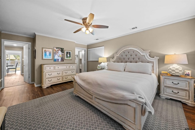 bedroom featuring dark wood-type flooring, ornamental molding, and ceiling fan