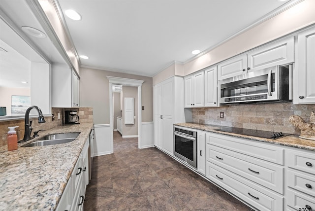 kitchen featuring white cabinetry, appliances with stainless steel finishes, sink, and backsplash