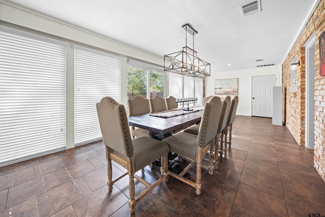 dining room with brick wall and a notable chandelier