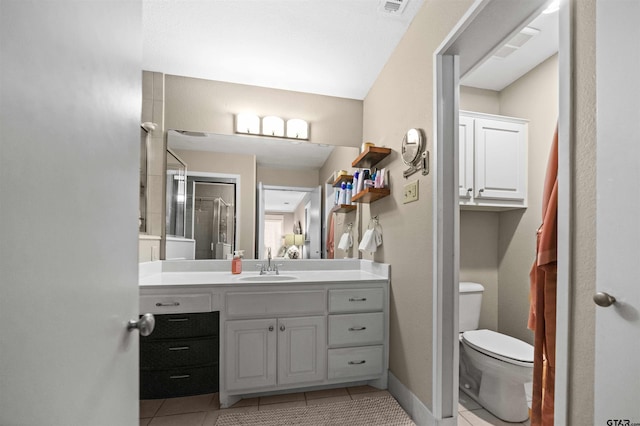 bathroom with toilet, vanity, and tile patterned floors