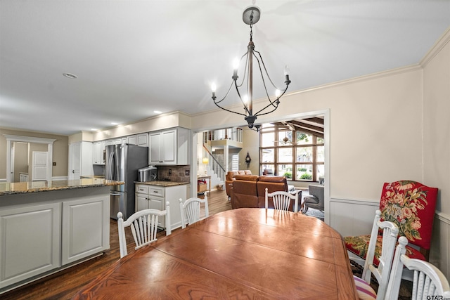 dining room featuring dark hardwood / wood-style flooring, a notable chandelier, and crown molding