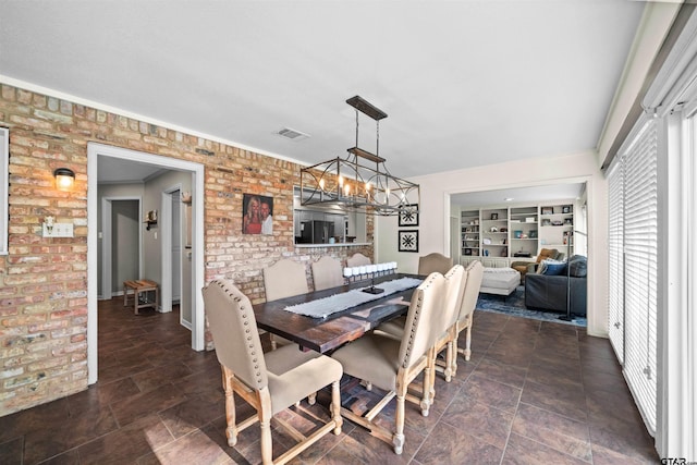 dining room featuring brick wall and a notable chandelier