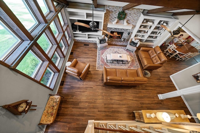 living room featuring a brick fireplace, a high ceiling, and dark hardwood / wood-style flooring