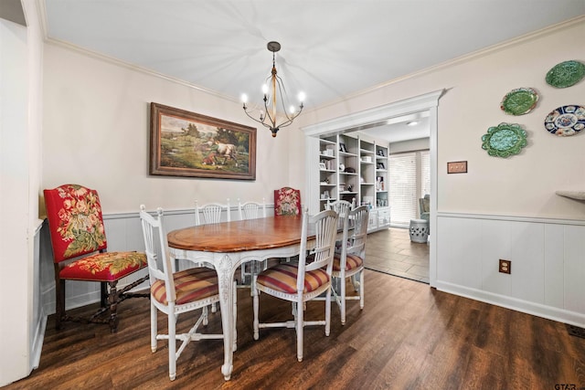 dining room featuring ornamental molding, built in shelves, dark hardwood / wood-style floors, and a chandelier