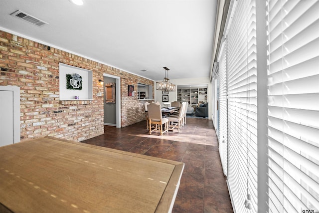 dining room with an inviting chandelier and brick wall