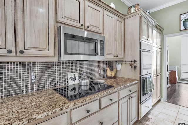 kitchen featuring light stone countertops, appliances with stainless steel finishes, backsplash, crown molding, and light hardwood / wood-style floors