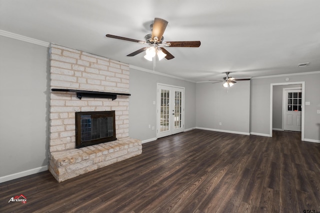 unfurnished living room featuring french doors, ornamental molding, dark hardwood / wood-style floors, and a brick fireplace