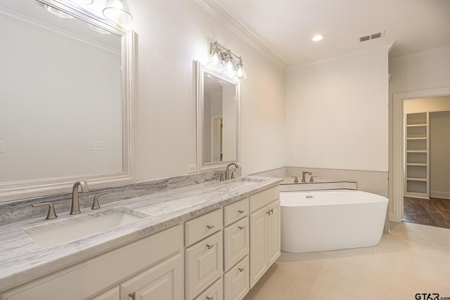 bathroom featuring ornamental molding, vanity, tile patterned floors, and a tub to relax in