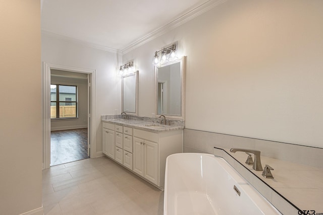 bathroom featuring vanity, ornamental molding, and a tub