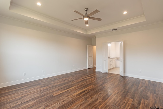 empty room featuring ornamental molding, dark hardwood / wood-style floors, and a raised ceiling