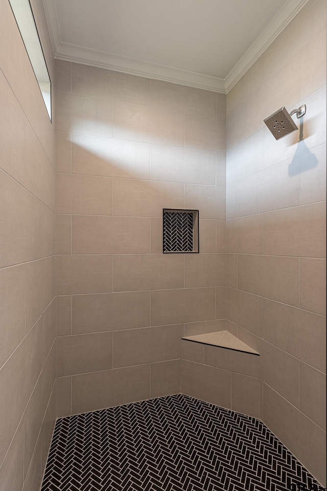 bathroom featuring crown molding and a tile shower