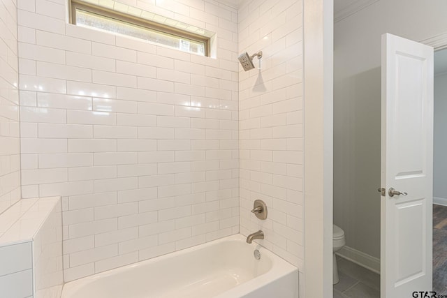 bathroom featuring tiled shower / bath and toilet