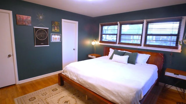 bedroom featuring hardwood / wood-style flooring and multiple windows