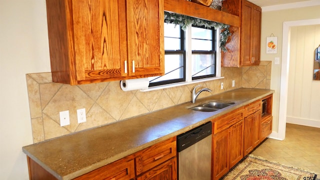 kitchen featuring tasteful backsplash, sink, light tile patterned floors, and stainless steel dishwasher